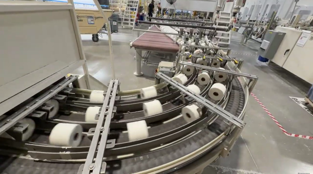 Rouleaux de papier sur un convoyeur à l’usine Cascades Tissu de Granby